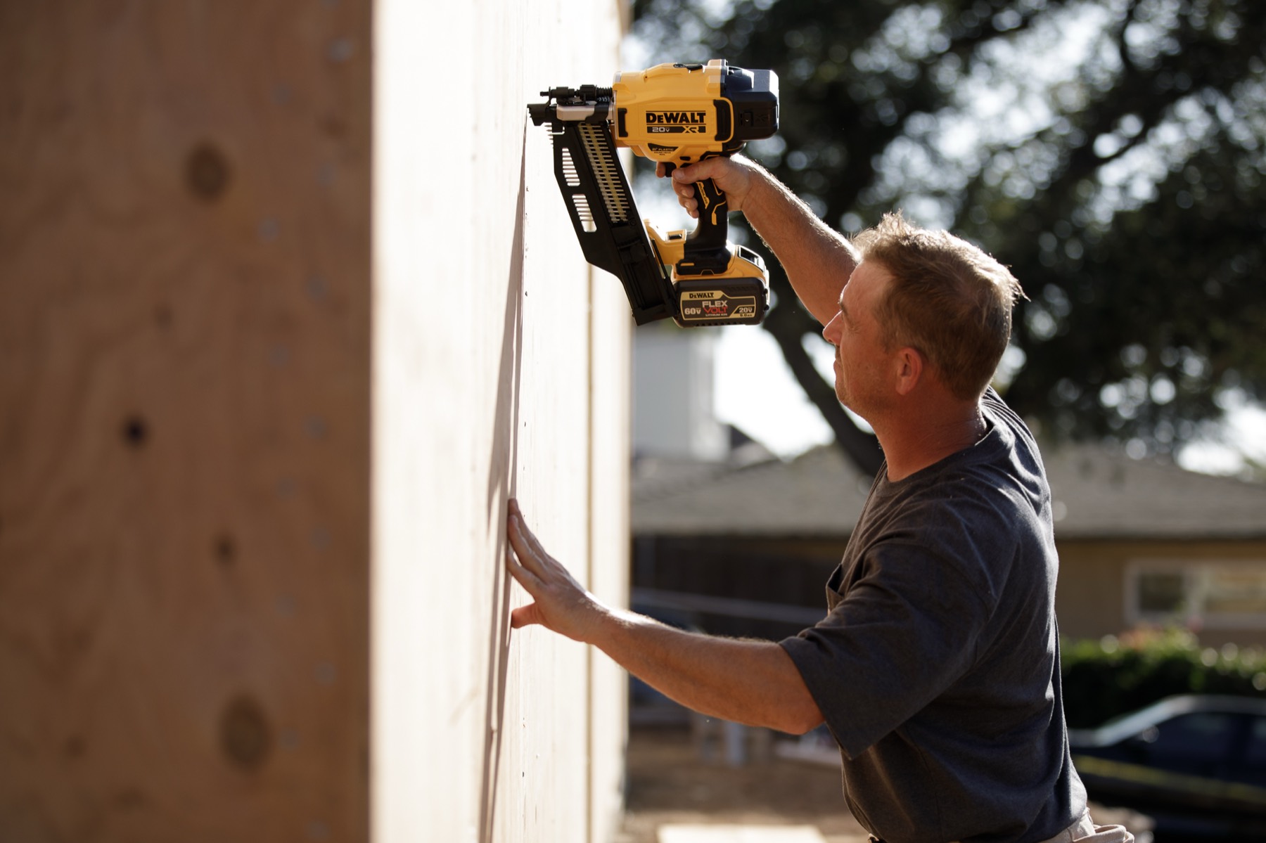 A Stud Finder carpenter nailing off wall sheathing